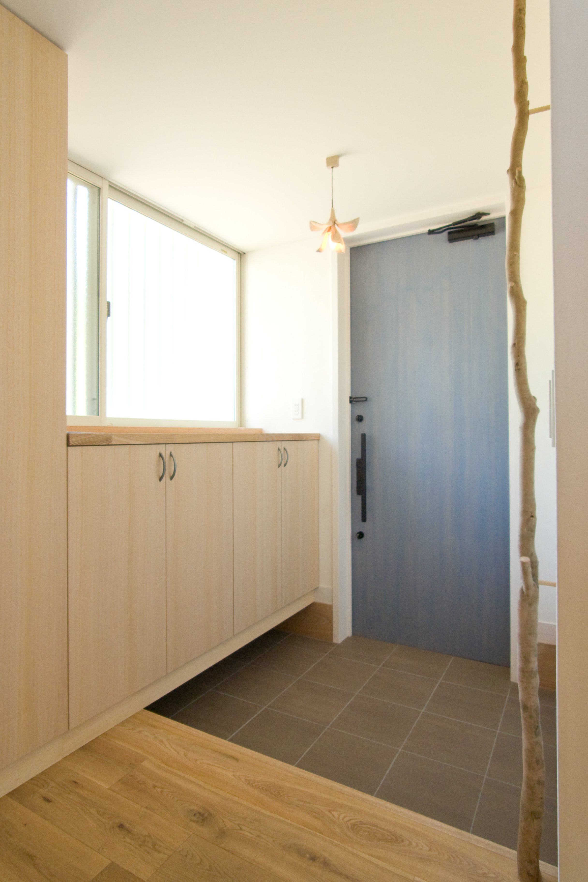 玄関＿水色の玄関ドアと枝手摺がアクセント