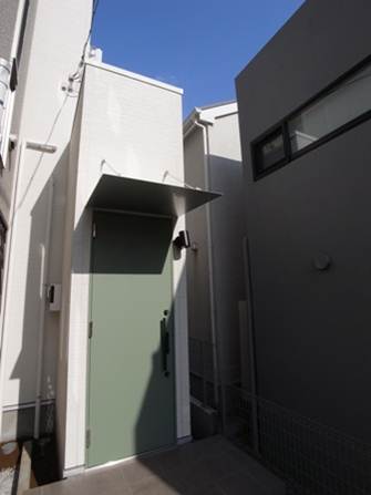 旗竿状敷地を有効活用して設けた玄関ポーチ。オリーブグリーンの玄関ドア。